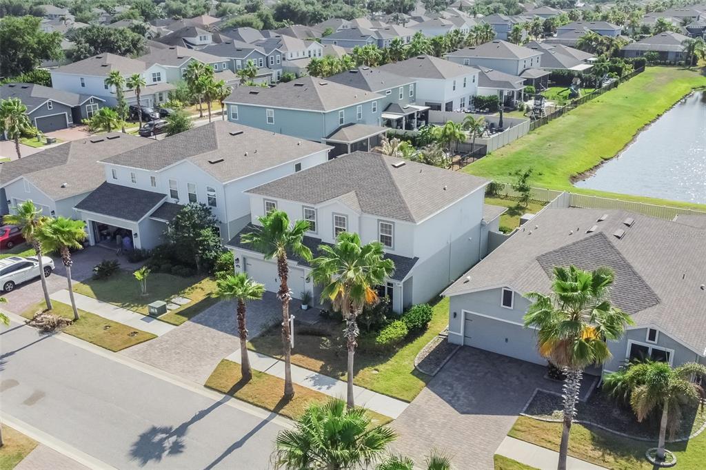 An aerial view shows several suburban houses with palm trees and a nearby pond — 12349 BLUE PACIFIC DRIVE, RIVERVIEW, FL