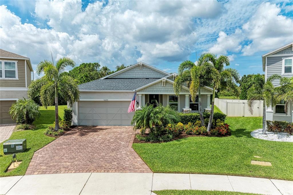 A screened-in patio features a swimming pool with an attached spa and stone tile decking — 14405 59TH CIRCLE E, BRADENTON, FL