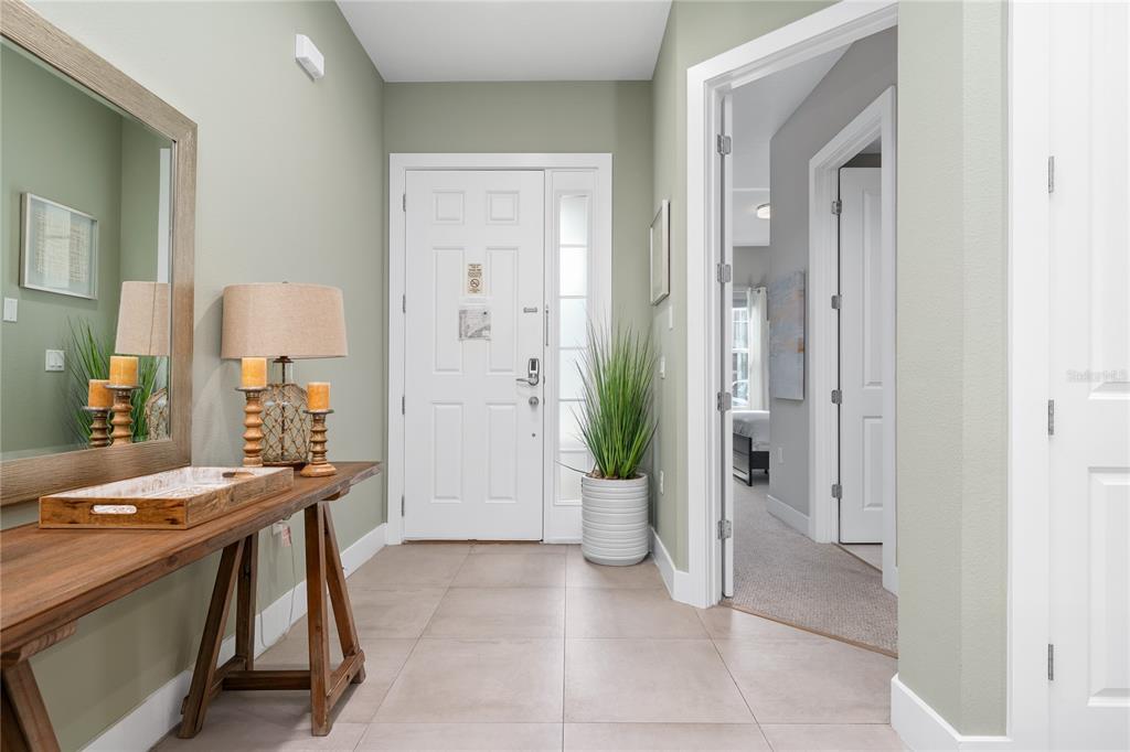 A foyer features light tile flooring, a wooden console table, and a white front door — 2614 SUNRISE SHORES DRIVE, KISSIMMEE, FL
