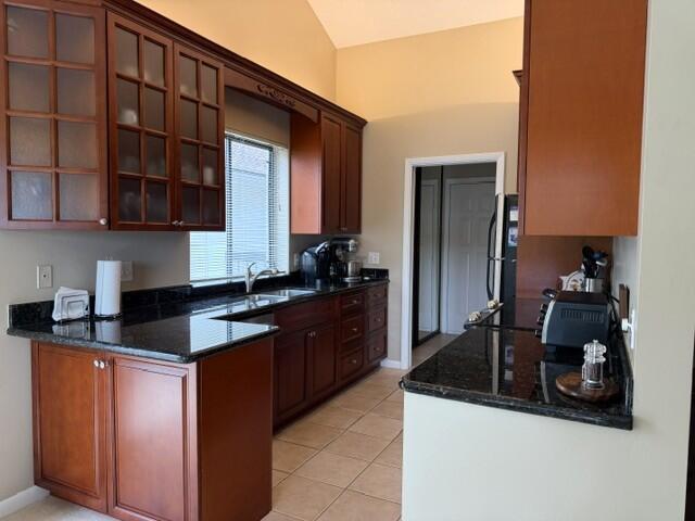 A kitchen features dark wood cabinets, granite countertops, and a window above the sink — 254 Ridge Road, Jupiter FL 33477, JUPITER, FL