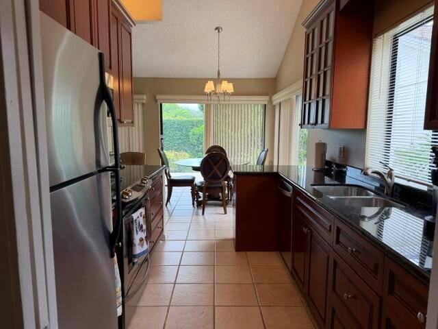 A kitchen with dark wood cabinets, granite countertops, and a dining area with sliding doors — 254 Ridge Road, Jupiter FL 33477, JUPITER, FL
