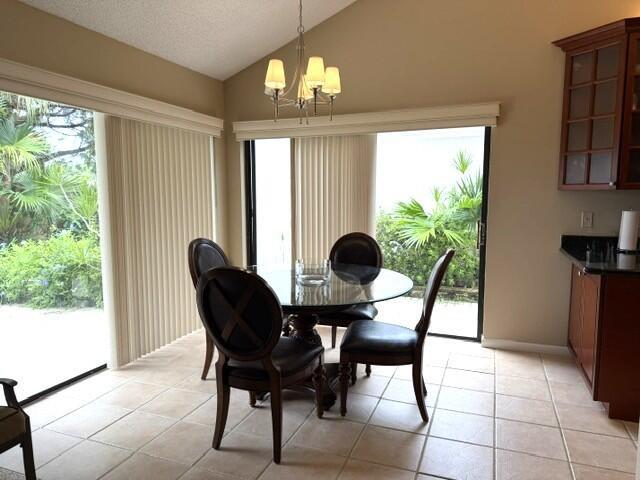 A dining area features a glass table, four chairs, a chandelier, and sliding glass doors — 254 Ridge Road, Jupiter FL 33477, JUPITER, FL