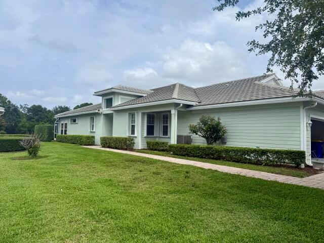 A light green single-story house with a tiled roof and a paved walkway in front — 4645 SE Bridgetown Court, Stuart FL 34997, STUART, FL