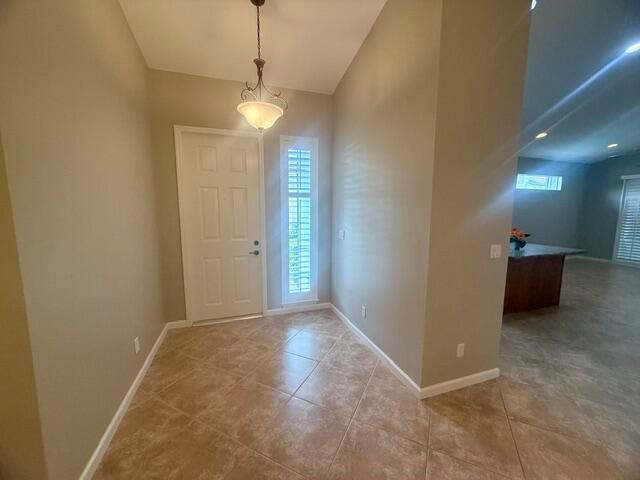 An entryway features a light-colored door, a hanging pendant light, and diagonal tile flooring — 4645 SE Bridgetown Court, Stuart FL 34997, STUART, FL