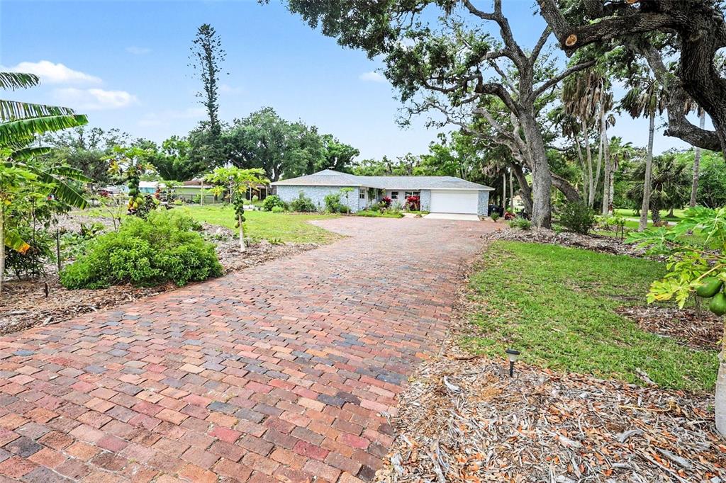 A rectangular swimming pool with a tiled patio and a wooden fence in a backyard — 1713 14TH AVENUE W, PALMETTO, FL