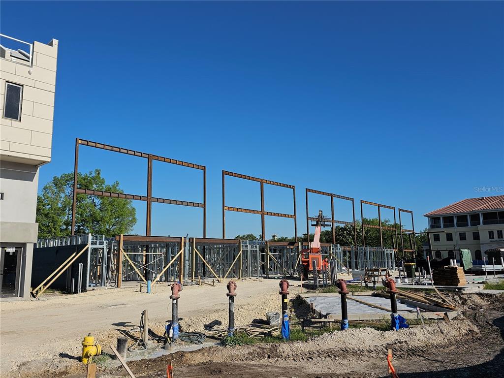 A construction site features exposed steel framing for a building under a clear blue sky — 10775 RODEO DRIVE UNIT tbd, LAKEWOOD RANCH, FL