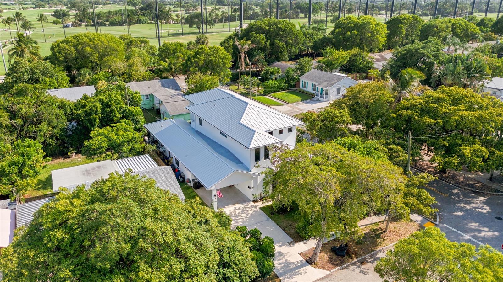 An aerial view of a two-story white house with a metal roof and driveway — 740 Winters Street, West Palm Beach FL 33405, WEST PALM BEACH, FL