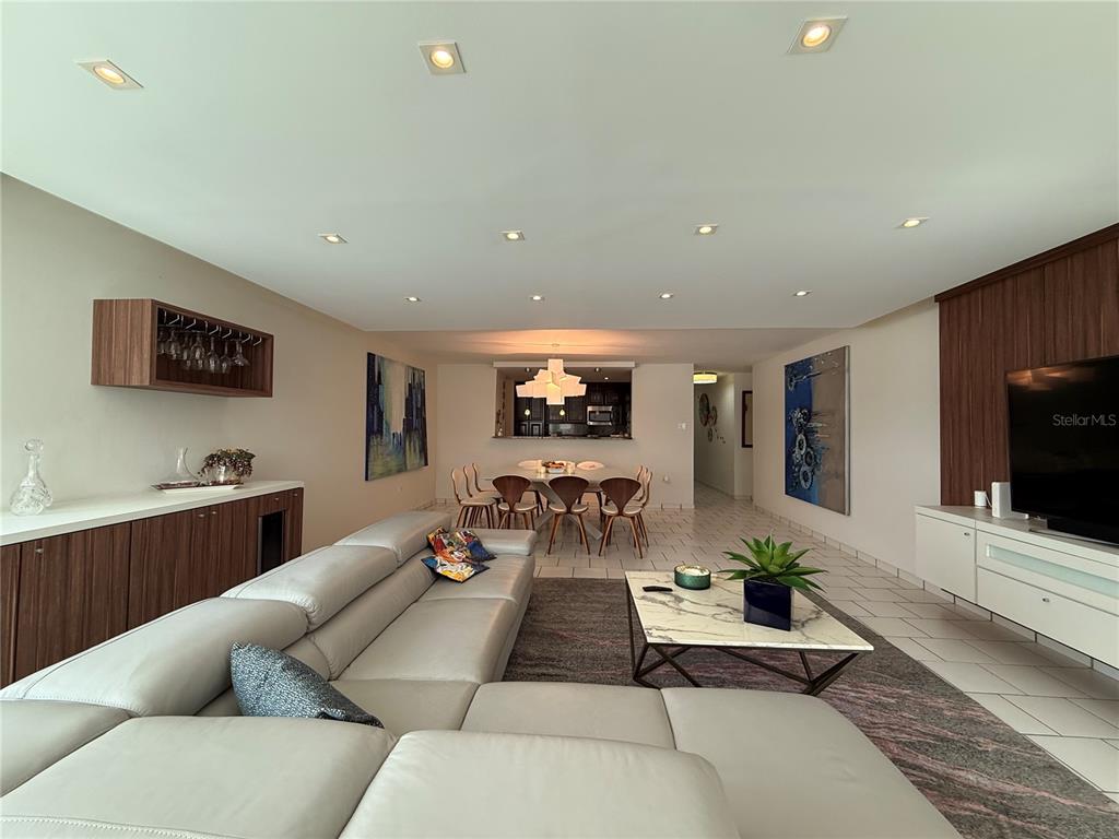 A modern living room features a large gray sectional, a marble coffee table, and dining area — 5245 ISLA VERDE AVENUE UNIT 208, CAROLINA, PR