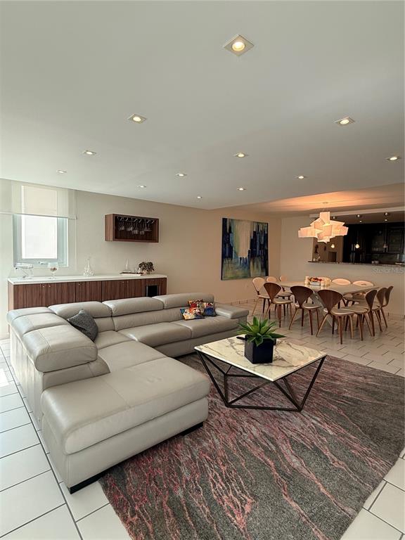 A living room features a large gray sectional sofa, a marble coffee table, and a dining area — 5245 ISLA VERDE AVENUE UNIT 208, CAROLINA, PR