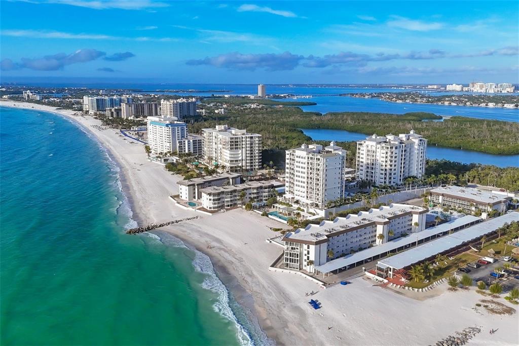 An aerial view of beachfront condominiums along a white sand beach and turquoise ocean — 2110 BENJAMIN FRANKLIN DRIVE UNIT 104, SARASOTA, FL