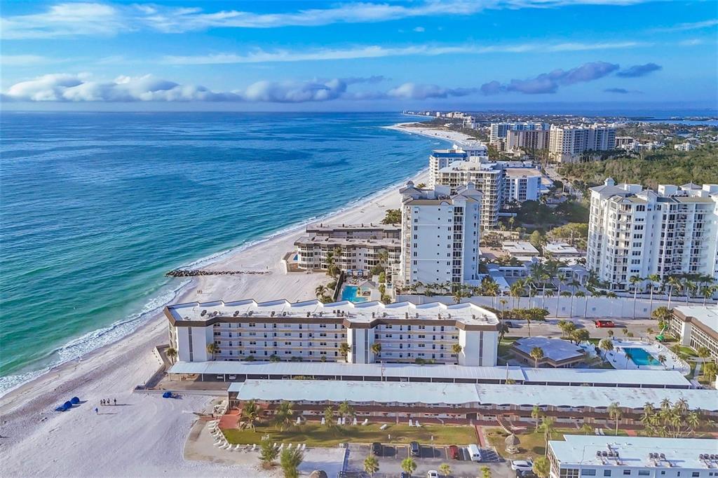 An aerial view of beachfront condominiums and a sandy beach along the ocean — 2110 BENJAMIN FRANKLIN DRIVE UNIT 104, SARASOTA, FL