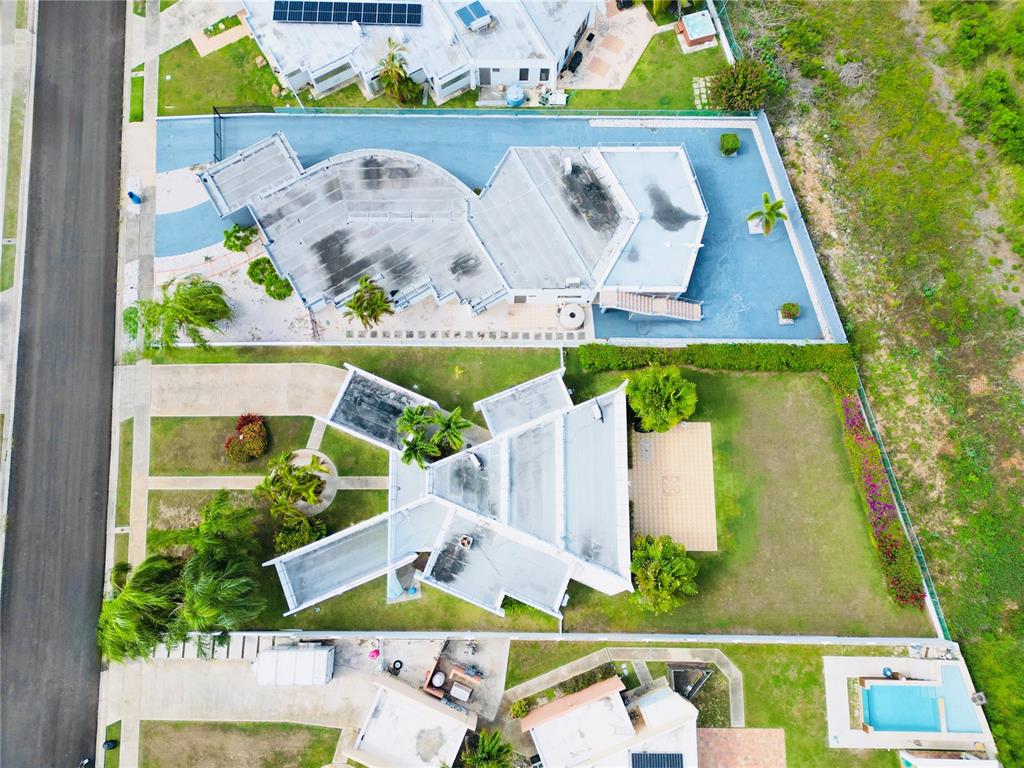 An aerial view shows two modern houses with unique geometric rooflines and surrounding landscaped yards — . VILLAS DE BAHIA UNIT D-7, LAJAS, PR