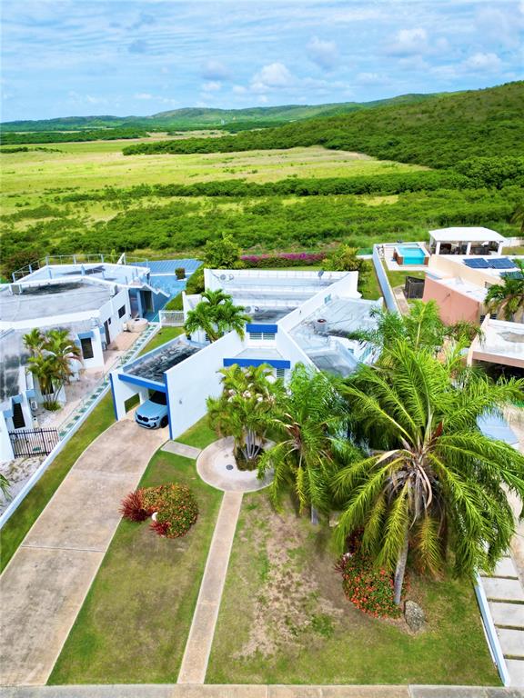An aerial view shows a modern white house with a carport and a tropical yard — . VILLAS DE BAHIA UNIT D-7, LAJAS, PR