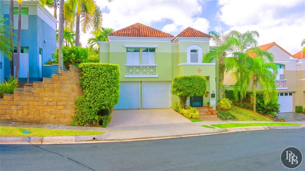 A two-story light green house with a two-car garage and a tiled roof — 49 Vereda Street MONTEVERDE REAL DEV, SAN JUAN, PR