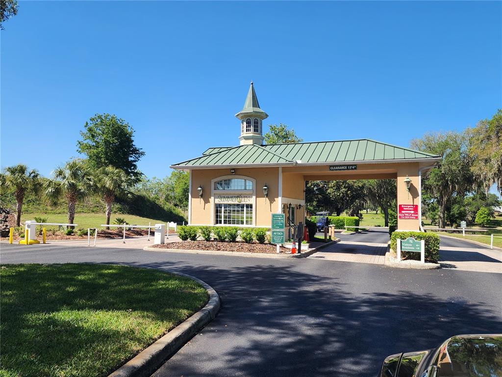 A gated community entrance features a guardhouse with a cupola and a green metal roof — 1715 SW 157TH PLACE ROAD, OCALA, FL