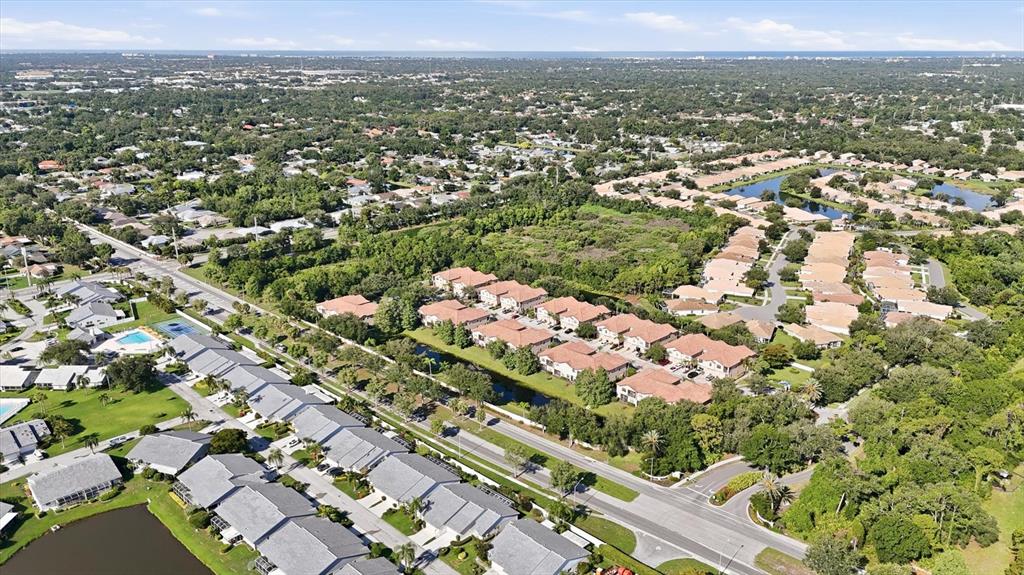 An aerial view shows a multi-unit residential complex with tile roofs and surrounding greenery — 4224 VIA PIEDRA CIRCLE UNIT 4-102, SARASOTA, FL