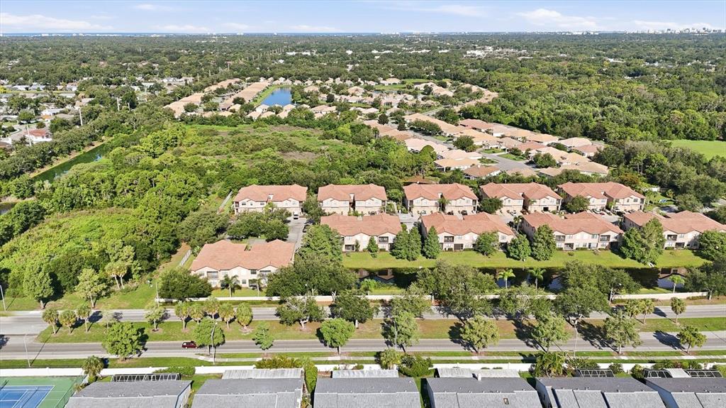 An aerial view shows a residential complex with multi-story townhomes surrounded by trees and greenery — 4224 VIA PIEDRA CIRCLE UNIT 4-102, SARASOTA, FL