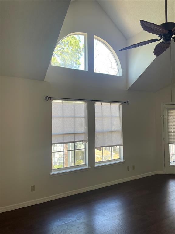 A room with dark wood floors, vaulted ceilings, two arched windows, and two rectangular windows — 5992 WESTGATE DRIVE UNIT 302, ORLANDO, FL