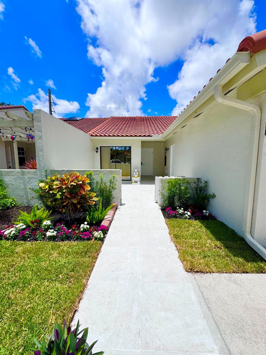 A paved walkway leads to the front entrance of a house with a tiled roof — 21547 Altamira Avenue, Boca Raton FL 33433, BOCA RATON, FL