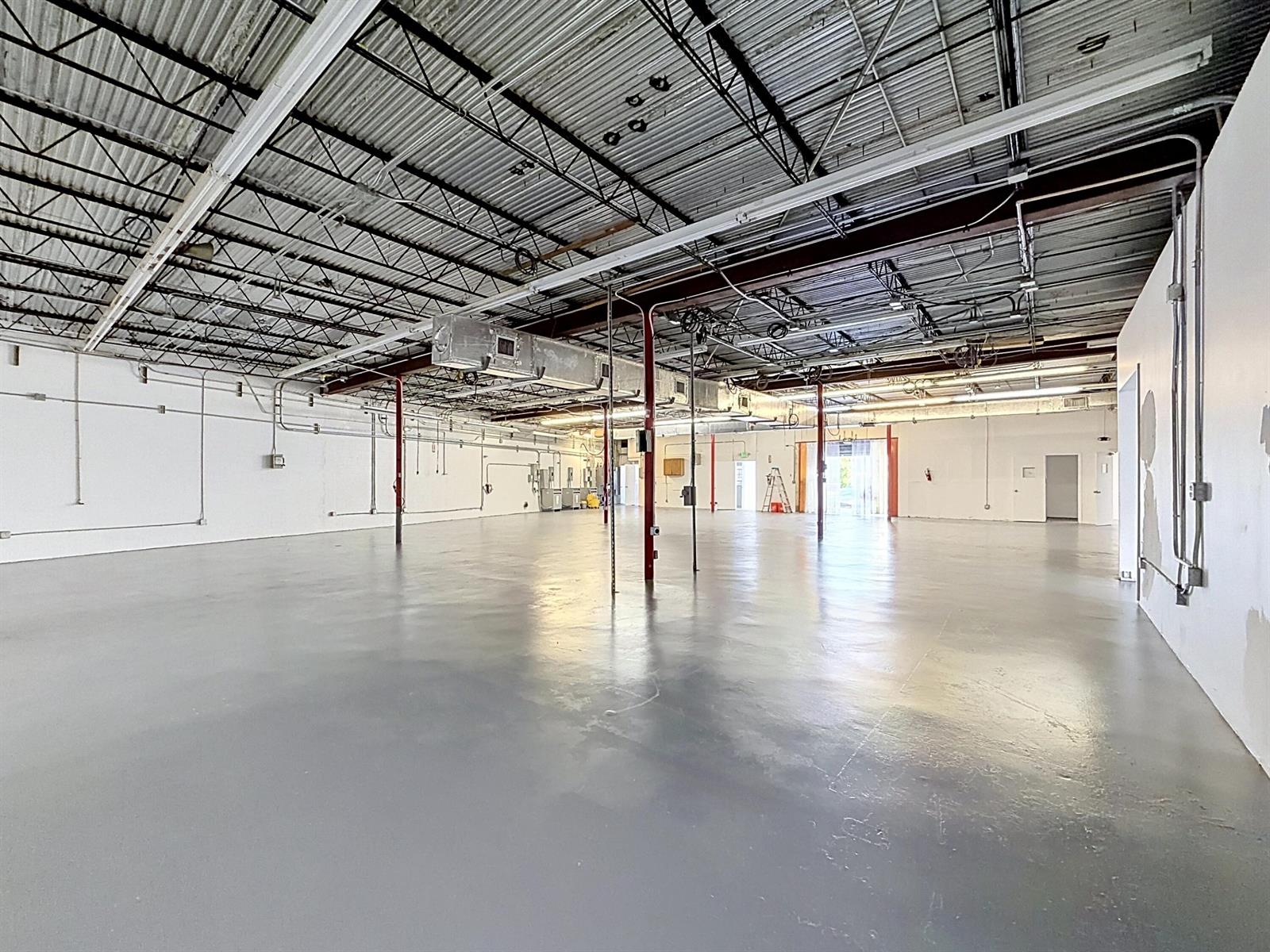 An empty industrial warehouse space features a gray concrete floor and exposed metal ceiling — 3411 NE 6th Terrace, Pompano Beach FL 33064, POMPANO BEACH, FL
