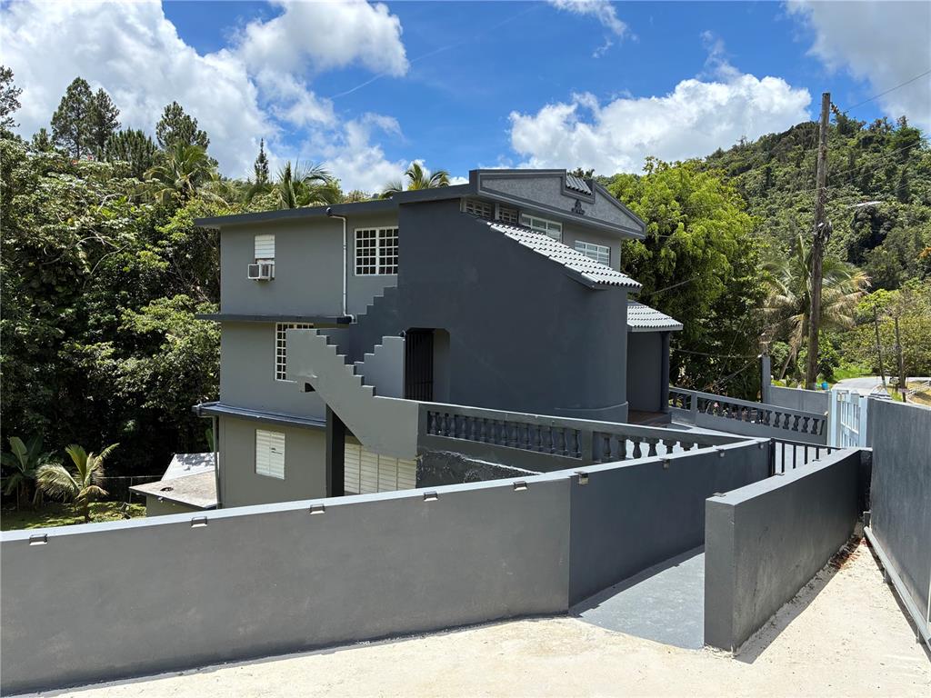 A multi-story gray house with an external staircase and a surrounding concrete wall — 743 KM 4.3 LA VEGA, GUAVATE UNIT 1, CAYEY, PR