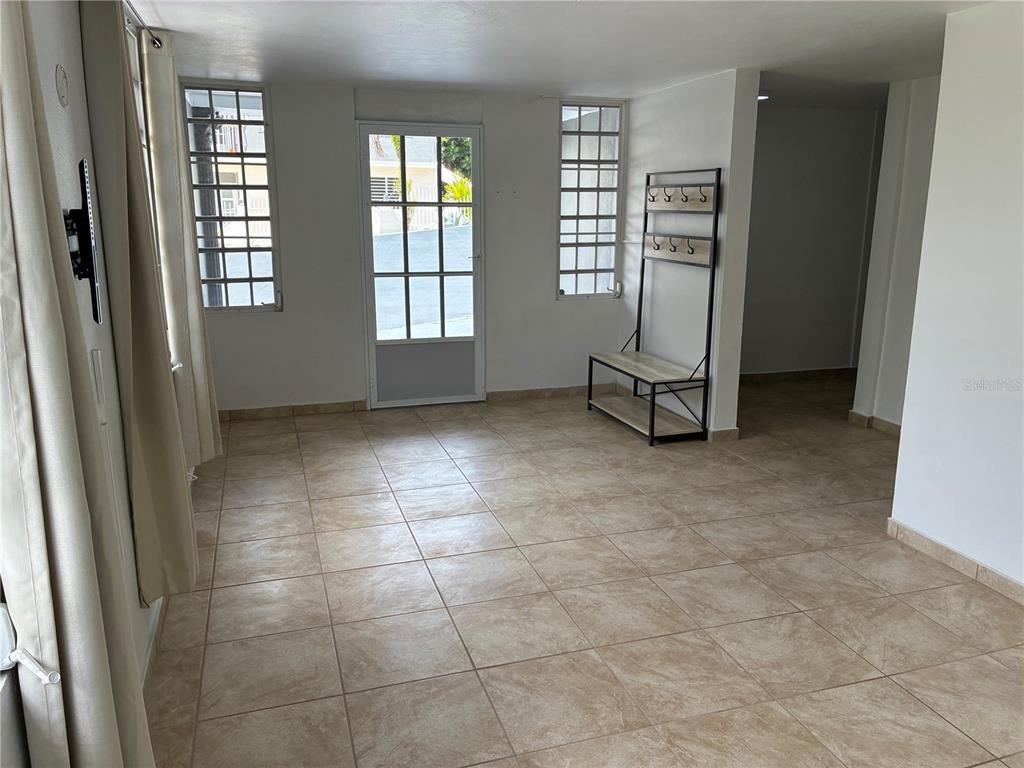 A room with beige tile flooring, white walls, a glass-paneled door, and a coat rack — 743 KM 4.3 LA VEGA, GUAVATE UNIT 1, CAYEY, PR
