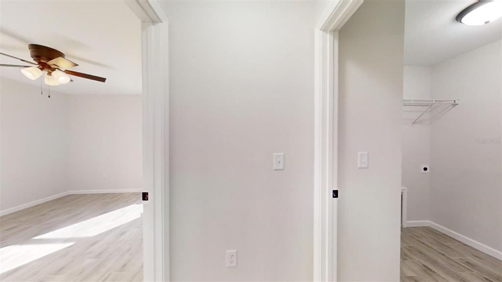 A hallway view shows two doorways leading to a bedroom and a laundry room — 217 OAK LANE ROAD, OCALA, FL