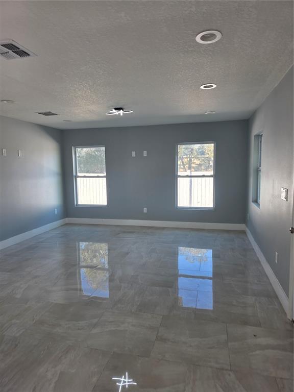 An empty room with gray walls, large windows, and polished light-colored tile flooring — 3704 SMITH TREE STREET, TAMPA, FL