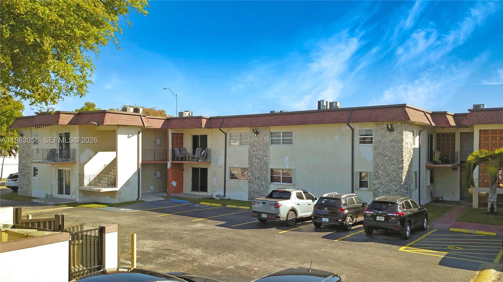 An exterior view of a two-story apartment building with a parking lot in front — 1275 W 35th St # 45B, Hialeah FL 33012, HIALEAH, FL