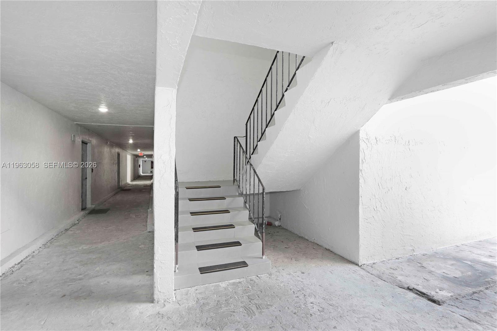 An outdoor concrete staircase with metal railings leads to an upper level in a hallway — 1275 W 35th St # 45B, Hialeah FL 33012, HIALEAH, FL