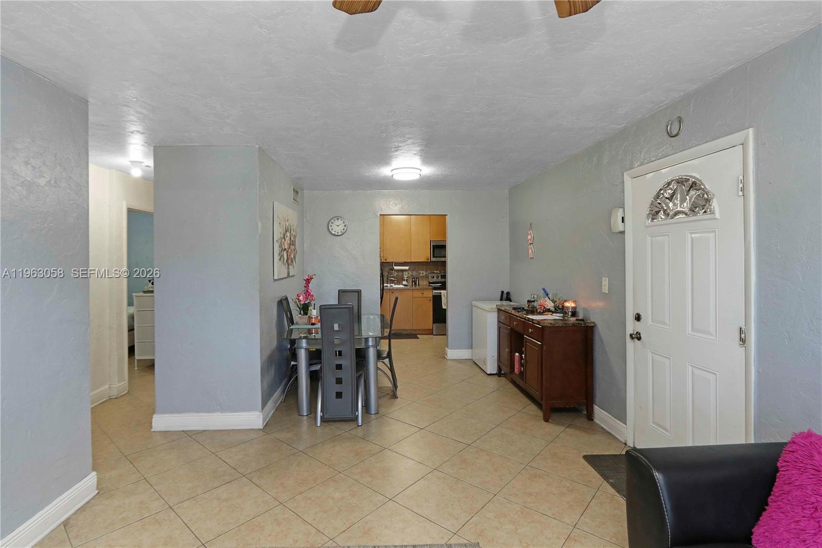 This dining area features tile flooring, a glass table, and an adjacent kitchen — 1275 W 35th St # 45B, Hialeah FL 33012, HIALEAH, FL