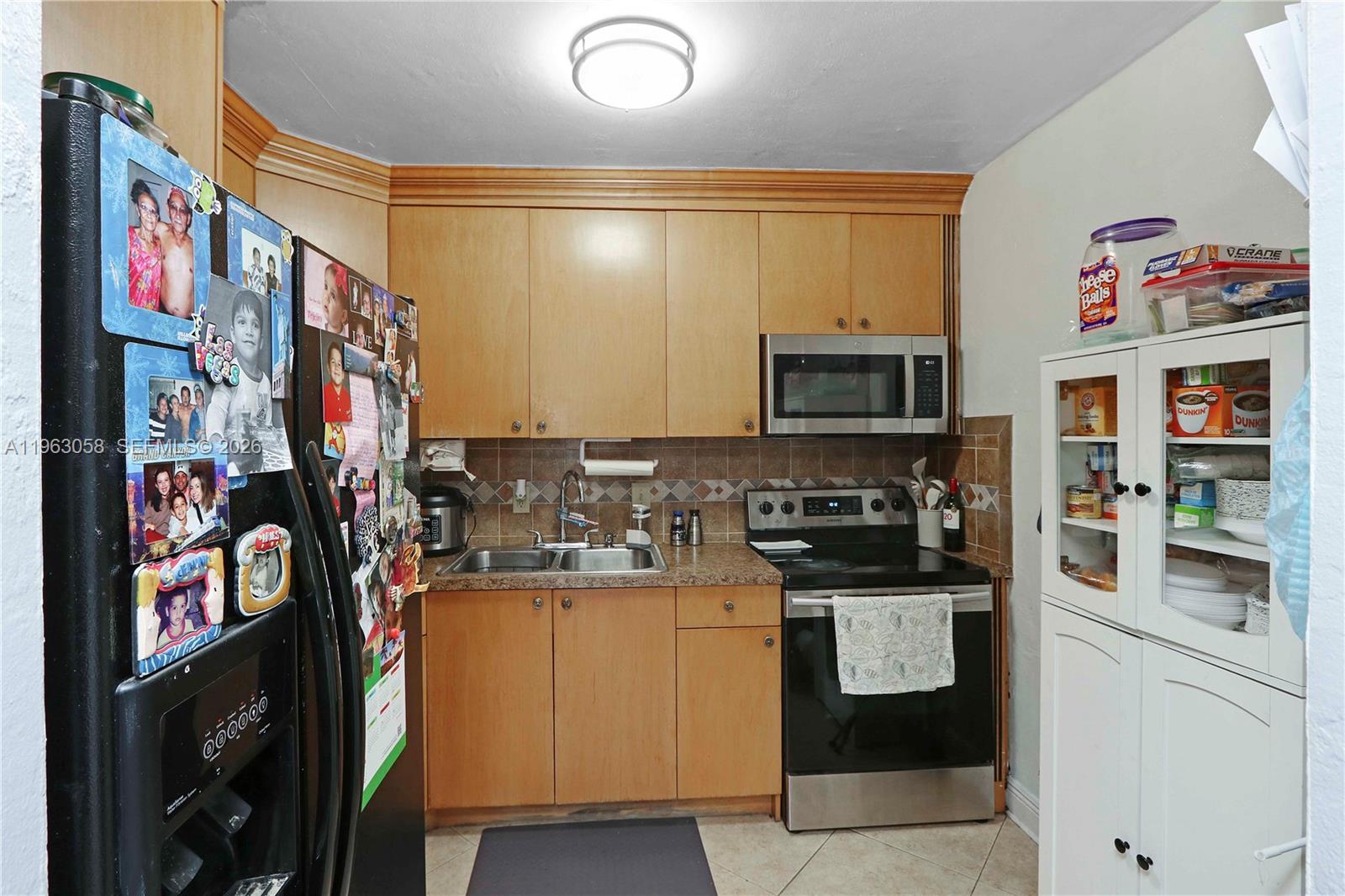 A kitchen features light wood cabinets, stainless steel appliances, and a tiled backsplash — 1275 W 35th St # 45B, Hialeah FL 33012, HIALEAH, FL