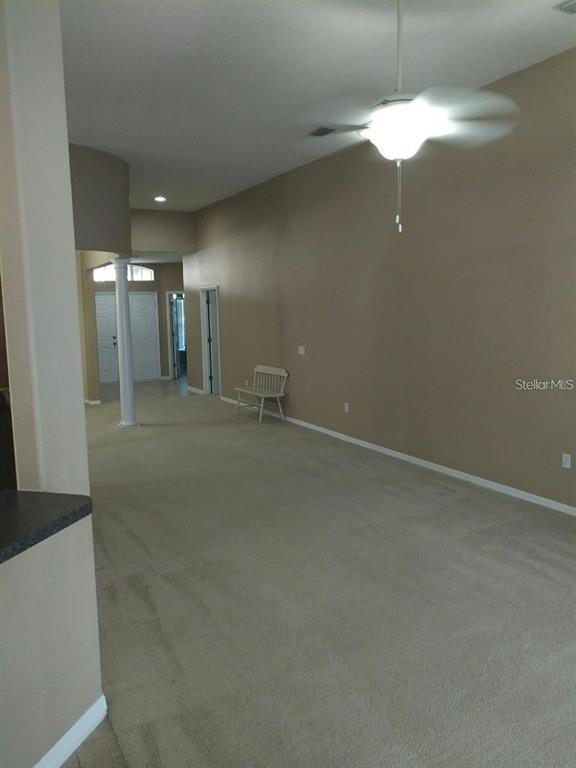 A carpeted living area features a ceiling fan, a white column, and a small bench — 5804 JUSTICIA LOOP, LAND O LAKES, FL