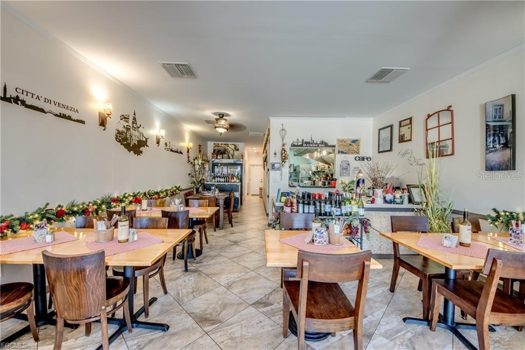 A restaurant dining room features wooden tables, chairs, tiled floors, and decorative wall art — 2414 TAMIAMI TRAIL UNIT C, PORT CHARLOTTE, FL