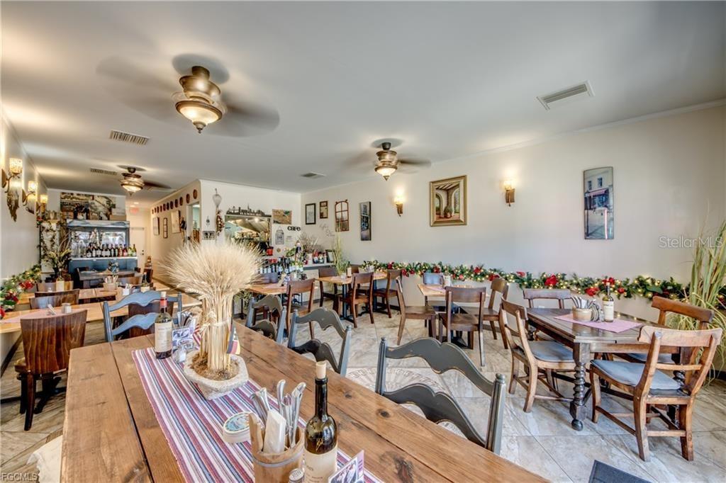 A restaurant dining room features multiple wooden tables, chairs, ceiling fans, and holiday garland decor — 2414 TAMIAMI TRAIL UNIT C, PORT CHARLOTTE, FL
