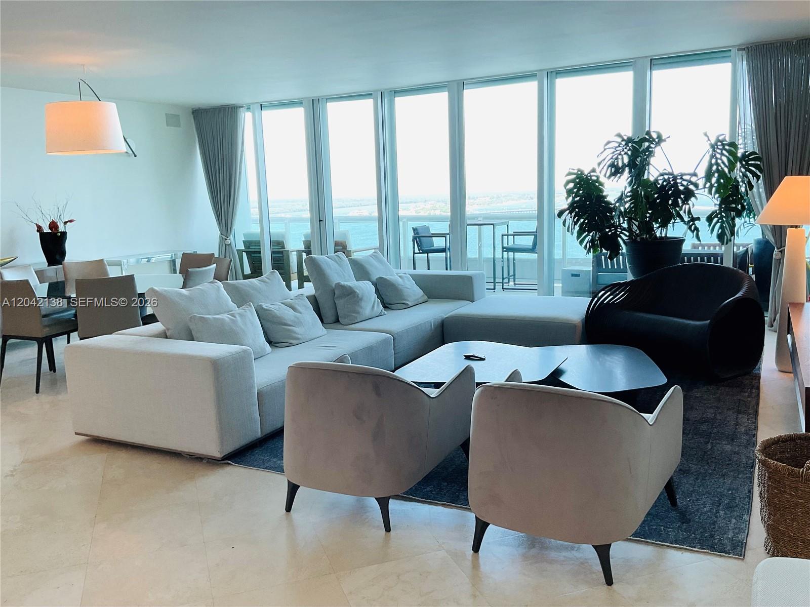 A modern living room features a large sectional sofa, two armchairs, and floor-to-ceiling windows — 1643 Brickell Ave # 2603, Miami FL 33129, MIAMI, FL