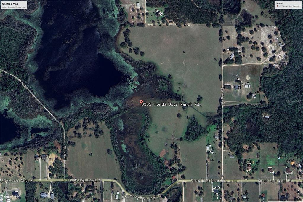 This is a satellite map view showing a rural property with fields and a lake — 8335 FLORIDA BOYS RANCH ROAD, GROVELAND, FL