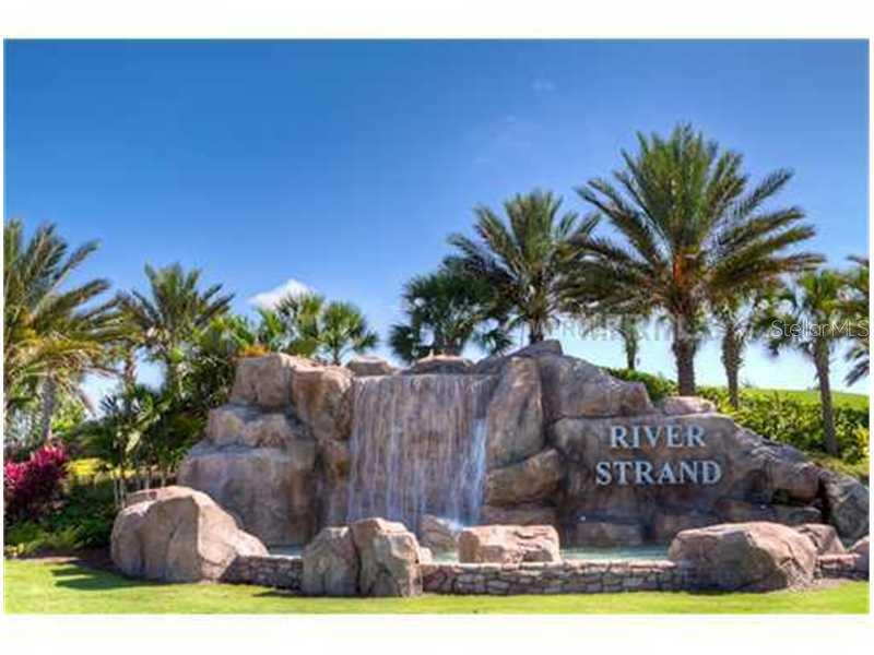 A large rock waterfall feature serves as a community entrance sign for River Strand — 8309 GRAND ESTUARY TRAIL UNIT 206, BRADENTON, FL