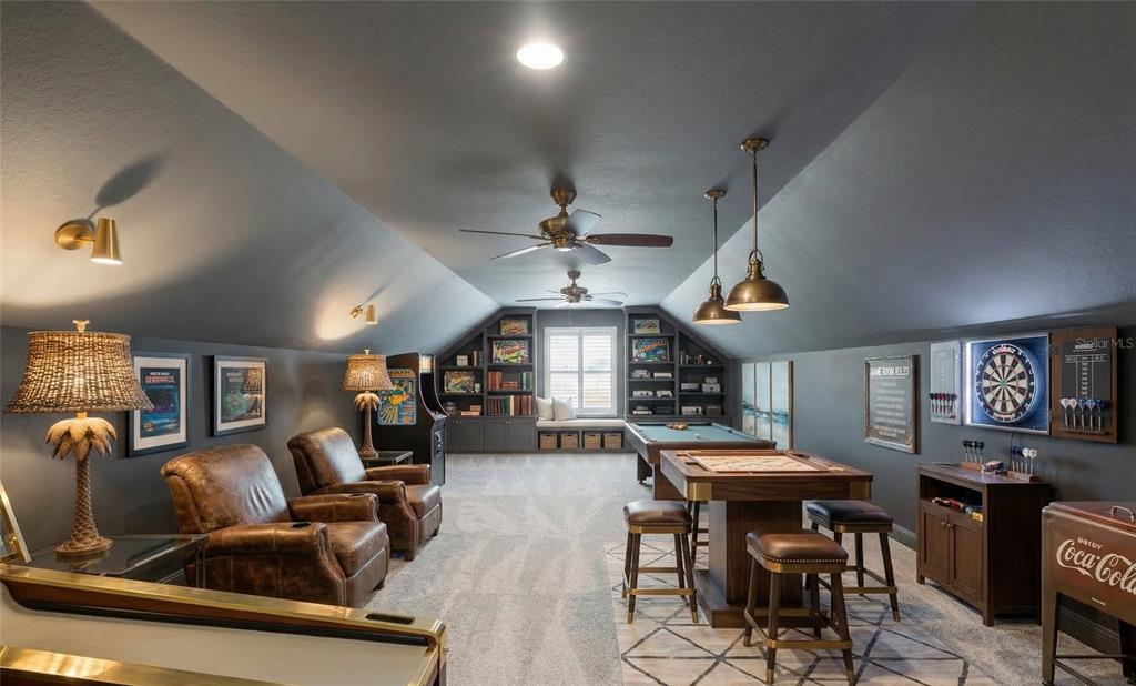 A game room features a pool table, dartboard, leather armchairs, and built-in shelving — 5845 STORMS AVENUE, THE VILLAGES, FL