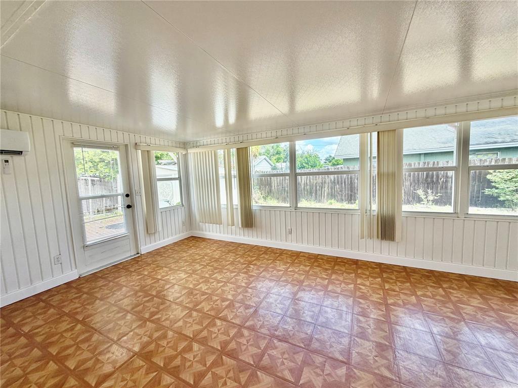A sunroom features white vertical paneled walls, a patterned tile floor, and large windows — 505 GLAD ROAD, WINTER HAVEN, FL