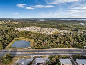 Aerial view of a residential neighborhood, a pond, a highway, and commercial buildings — TBD US HIGHWAY 27/441, FRUITLAND PARK, FL