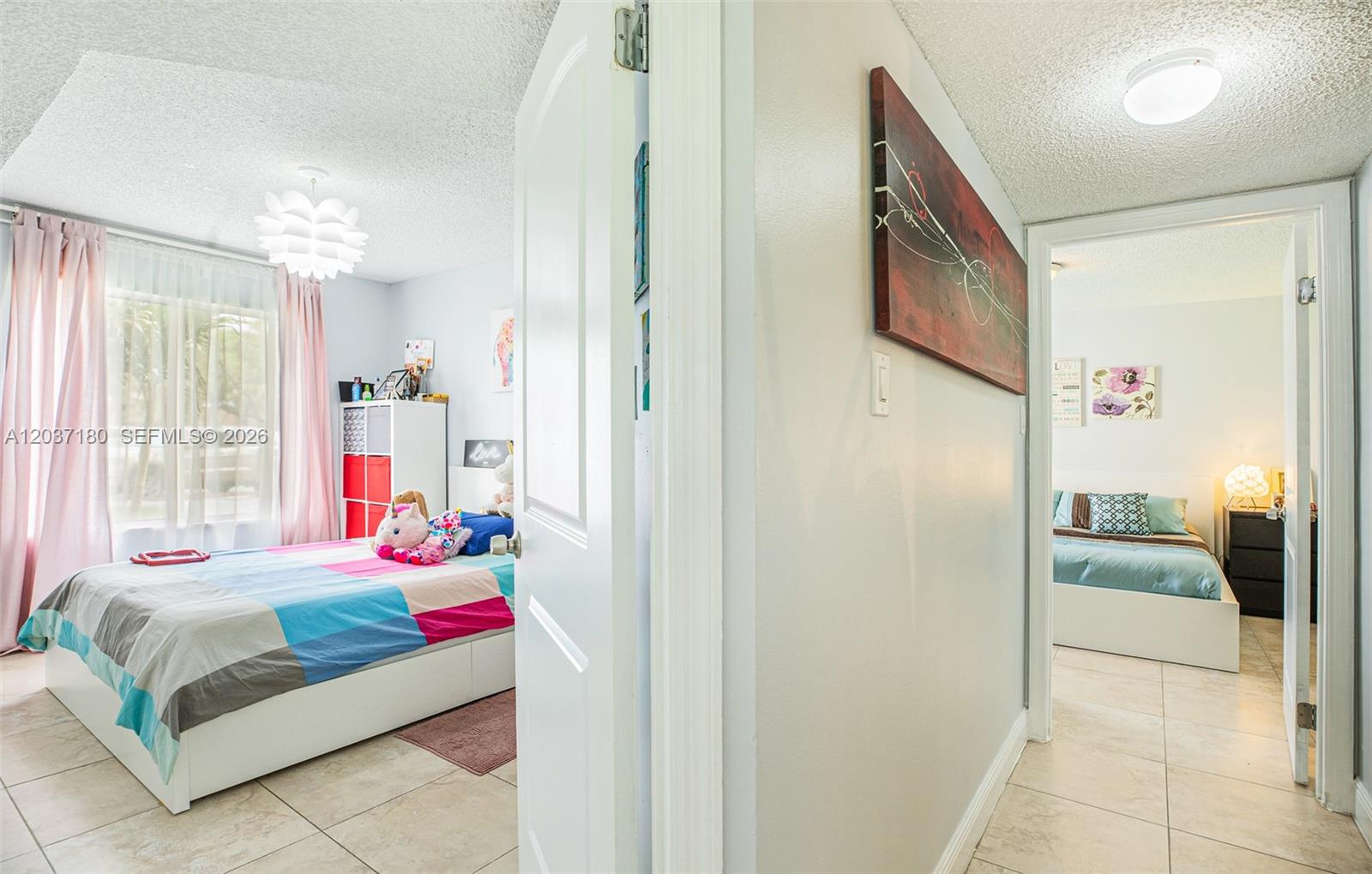 A hallway connects two bedrooms featuring tiled floors and white doors — 15780 SW 106th Ter # 107, Miami FL 33196, MIAMI, FL