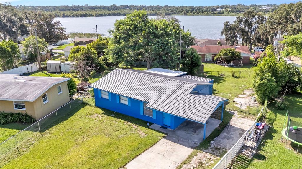 An aerial view shows a blue house with a metal roof and a concrete driveway — 707 N LORRI AVENUE, LAKELAND, FL