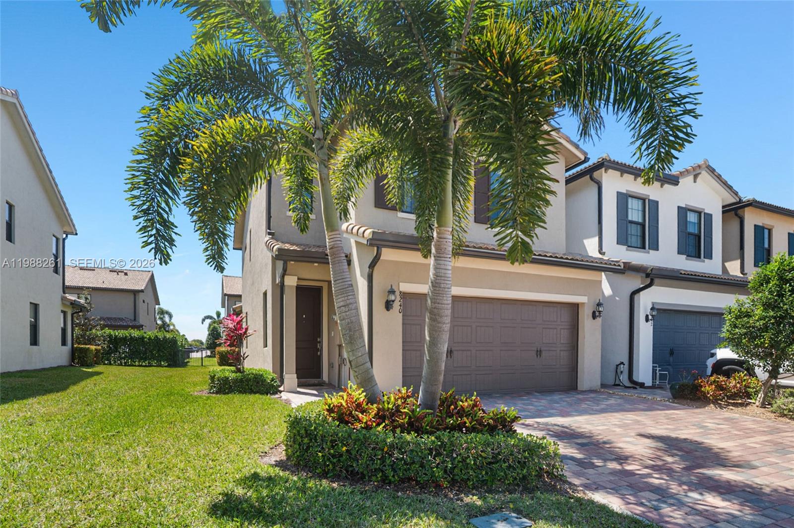 A kitchen features dark wood cabinetry, white countertops, a large island, and light wood flooring — 8240 Tailshot Ct, Lake Worth FL 33467, LAKE WORTH, FL