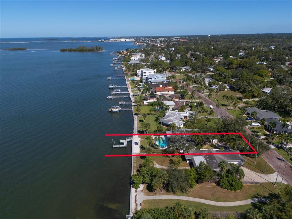 An aerial view shows a waterfront house with a private dock and swimming pool — 1614 SANTA BARBARA DRIVE, DUNEDIN, FL