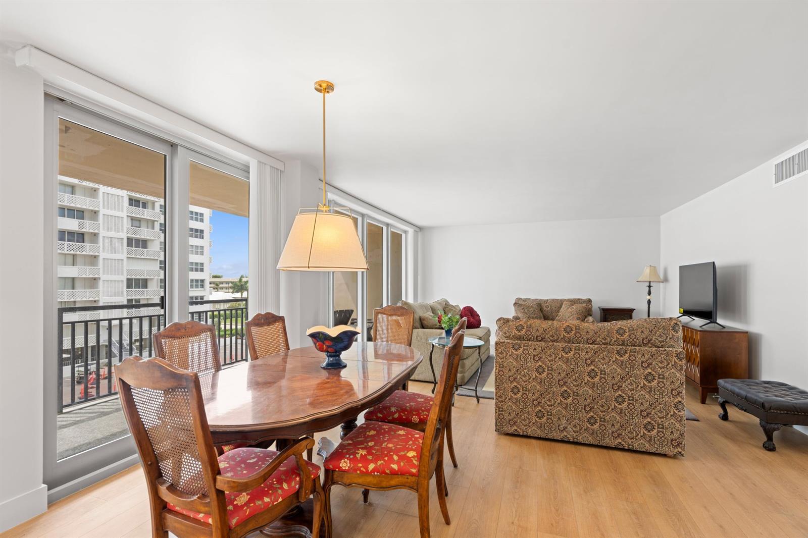 A dining area with a wooden table and chairs sits adjacent to a living room — 1180 S Ocean # 0044, Boca Raton FL 33432, BOCA RATON, FL