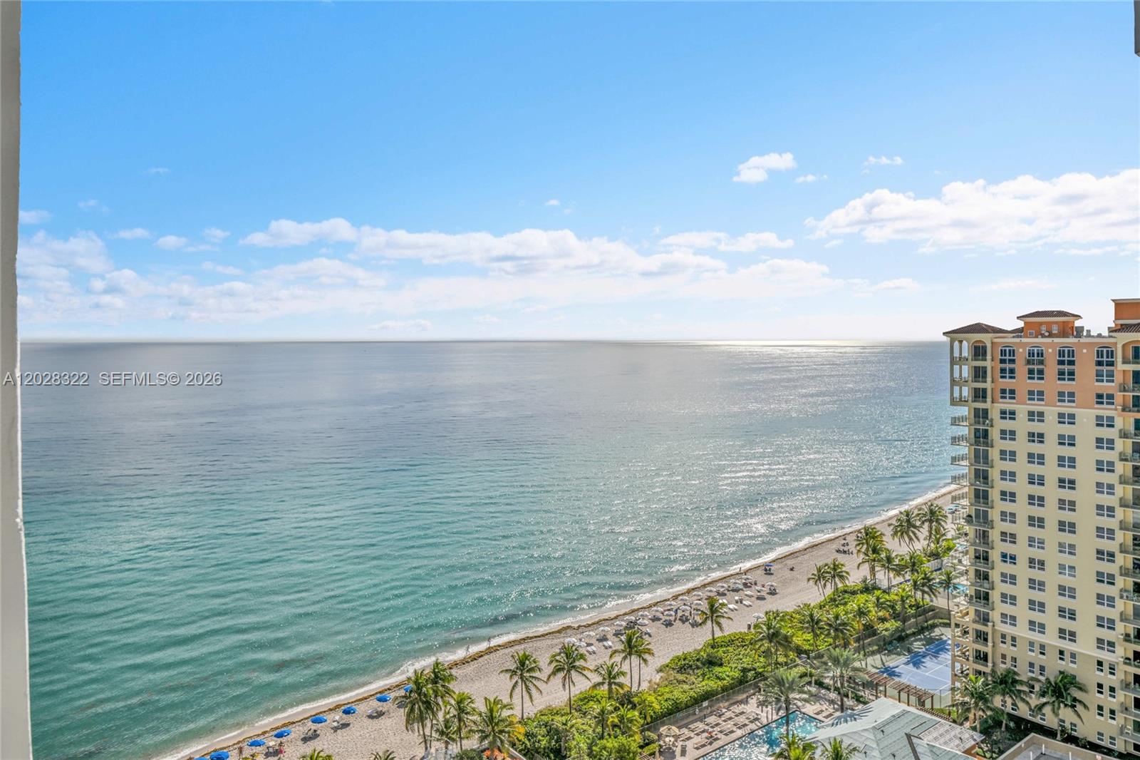 An elevated view shows a sandy beach, the ocean, and a tall residential building — 2030 S Ocean Dr # 2018, Hallandale Beach FL 33009, HALLANDALE BEACH, FL