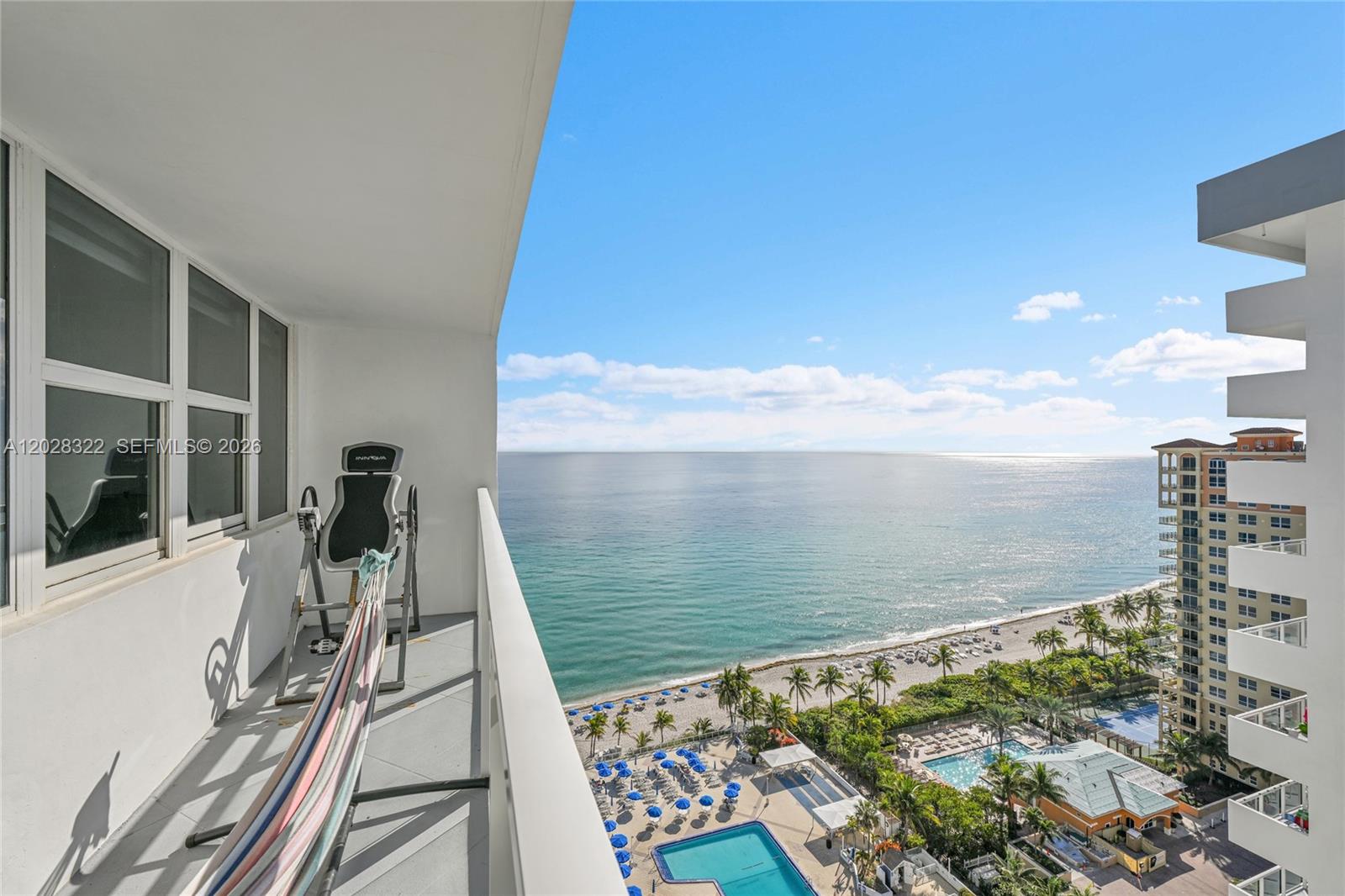 A balcony with an inversion table and hammock overlooks the ocean, beach, and pool — 2030 S Ocean Dr # 2018, Hallandale Beach FL 33009, HALLANDALE BEACH, FL