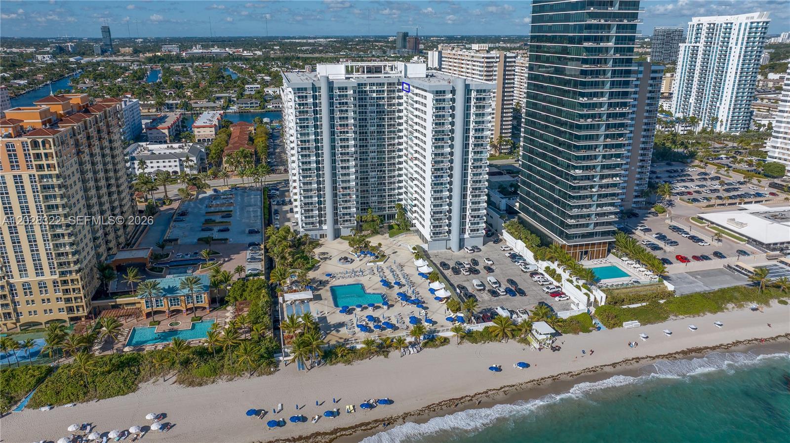 An aerial view shows a high-rise residential complex with pools and parking near the beach — 2030 S Ocean Dr # 2018, Hallandale Beach FL 33009, HALLANDALE BEACH, FL
