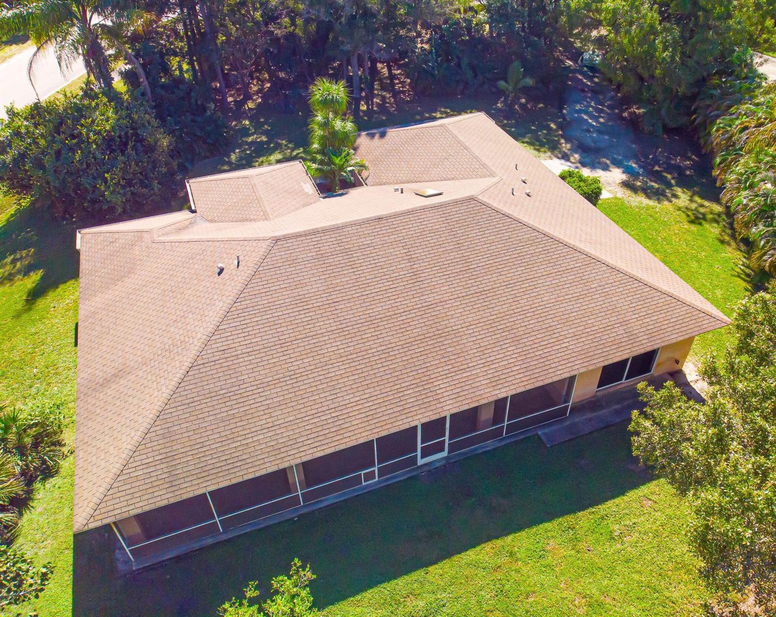 An aerial view of a house with a brown shingled roof and a screened-in porch — 12523 169th Court N, Jupiter FL 33478, JUPITER, FL